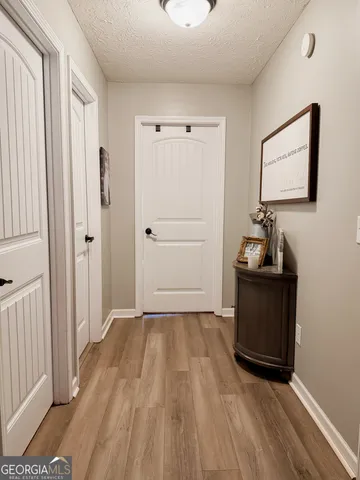 a hallway view with wooden floor and cabinet