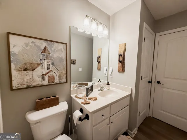a bathroom with a toilet sink and mirror