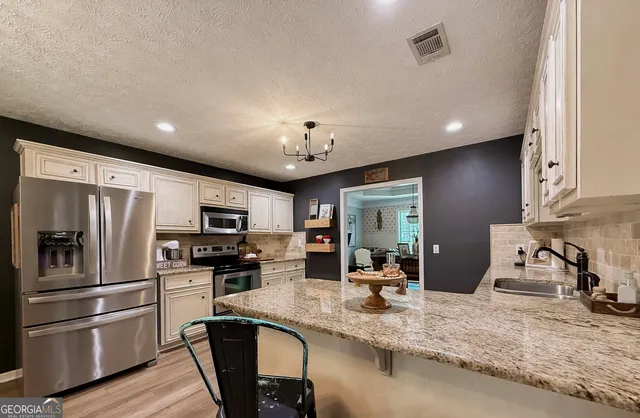 a kitchen with stainless steel appliances granite countertop a sink refrigerator and microwave