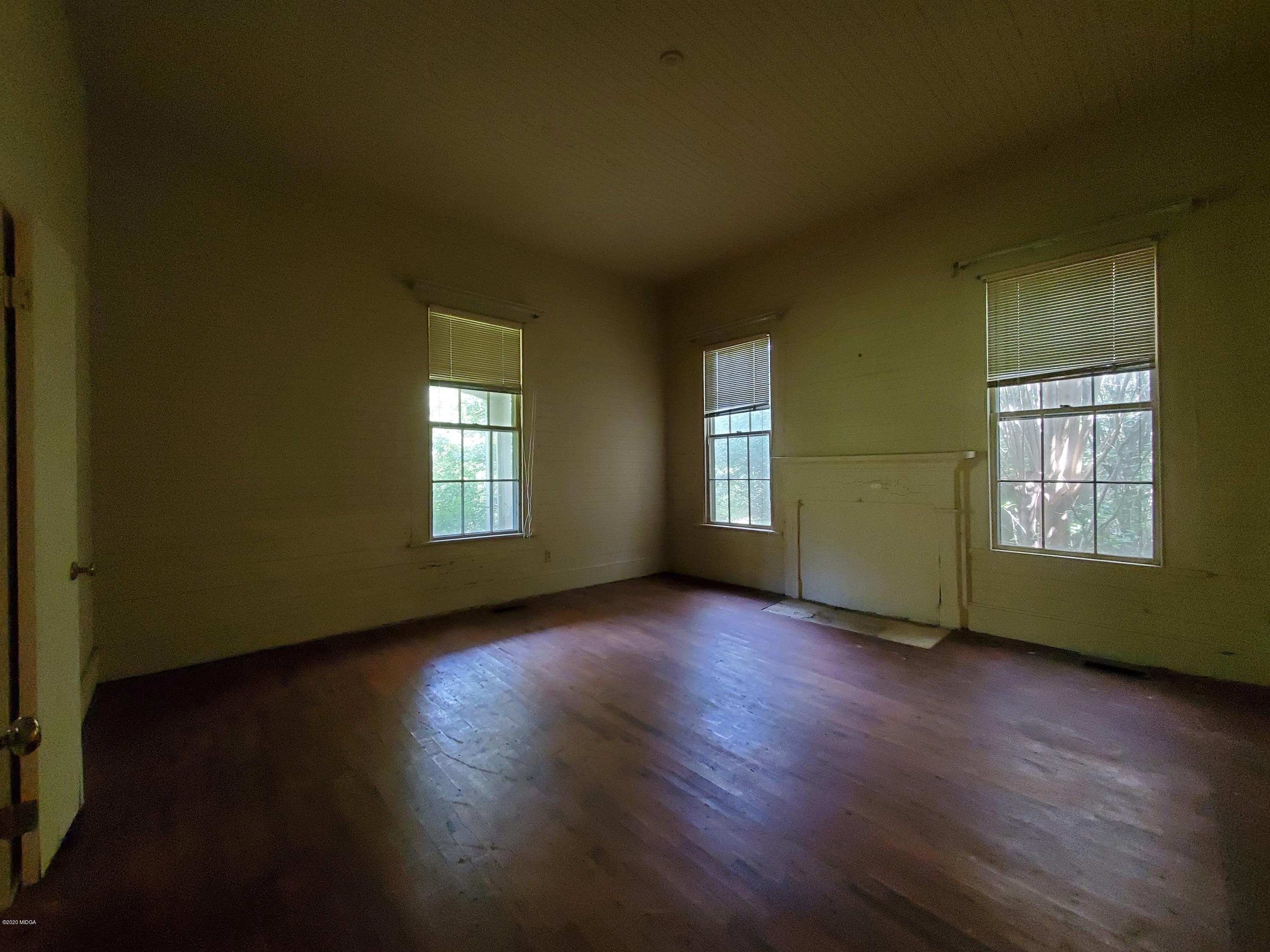 968 Rogers Church Road Forsyth, GA 31029 - Photo 7 of 14 an empty room with wooden floor and windows