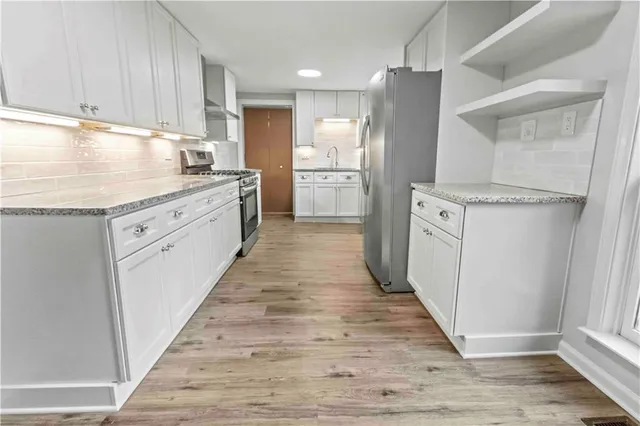 a kitchen with stainless steel appliances granite countertop a sink stove and refrigerator