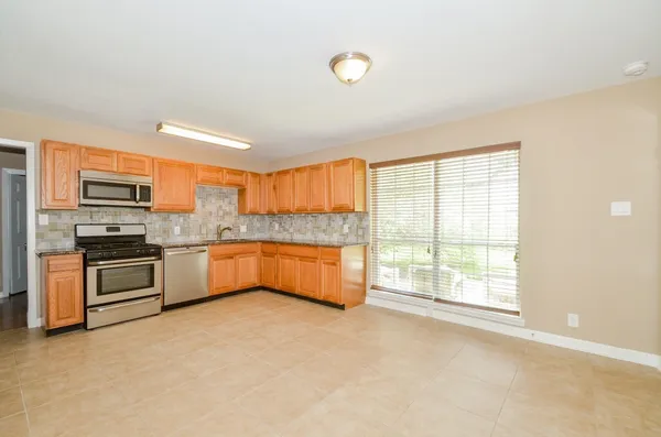 a kitchen with stainless steel appliances a white stove top oven a sink and dishwasher next to a window