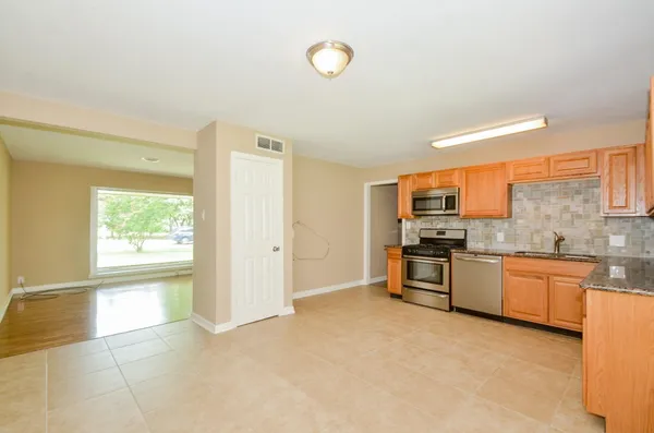 a large kitchen with a stove a sink dishwasher and a refrigerator