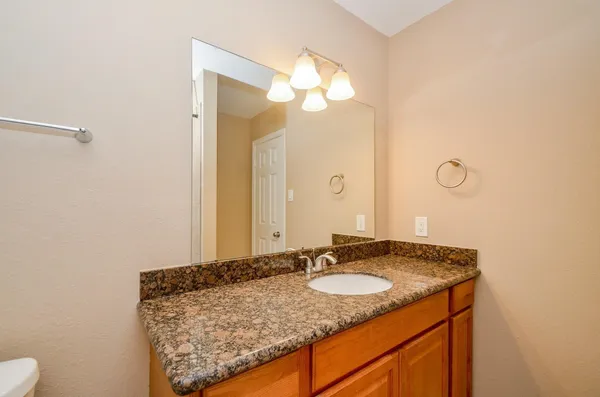 a bathroom with a granite countertop sink and a mirror