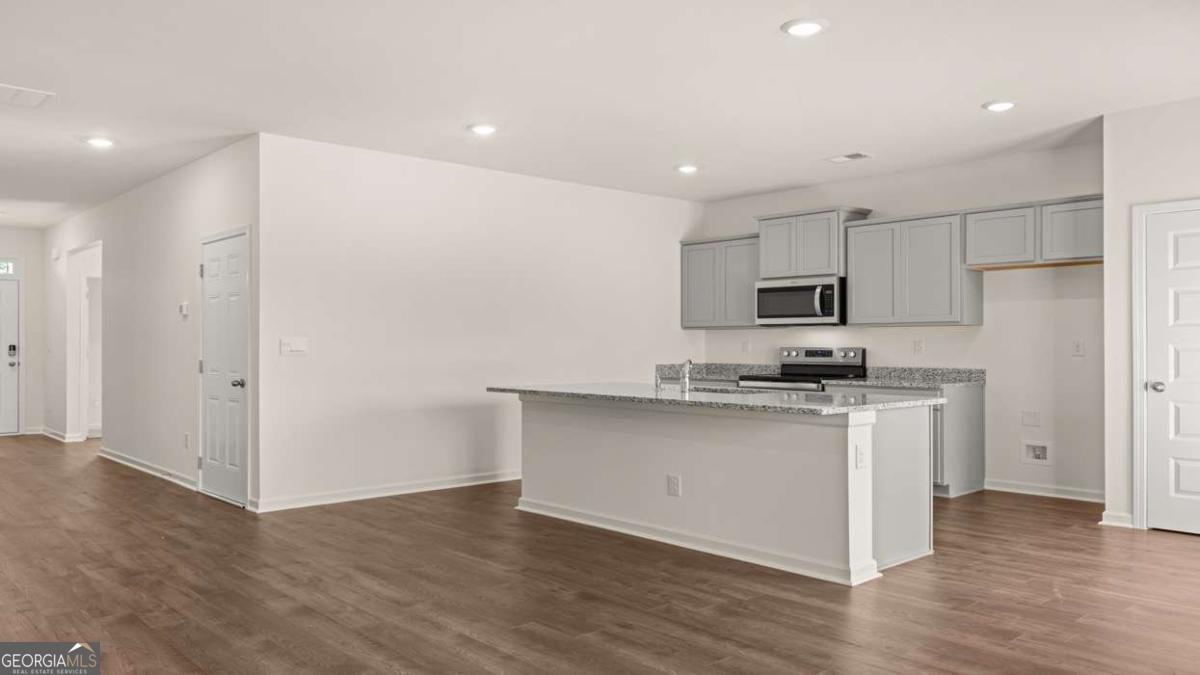 8576 Seabiscuit Road Lithonia, GA 30058 - Photo 10 of 22 a kitchen with stainless steel appliances a sink stove and wooden floor