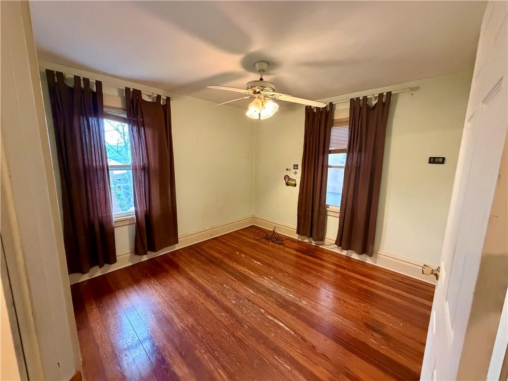 118 Ida Avenue Donora, PA 15033 - Photo 11 of 18 a view of a hallway with wooden floor and a ceiling fan