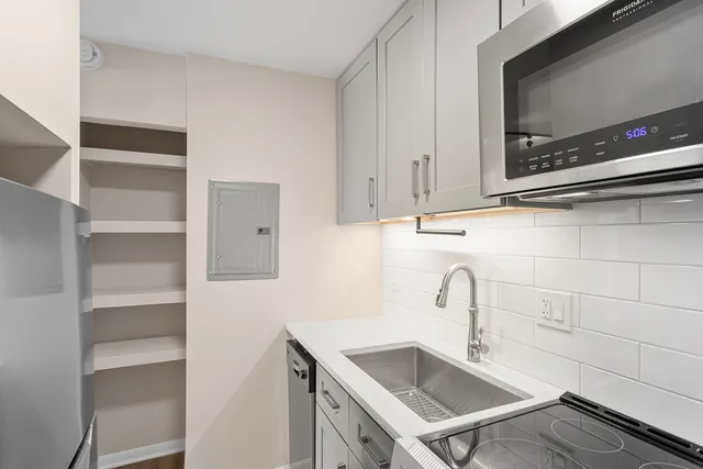 a kitchen with a sink cabinets and stainless steel appliances
