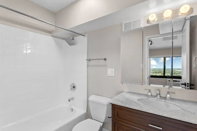 a bathroom with a granite countertop sink toilet and shower