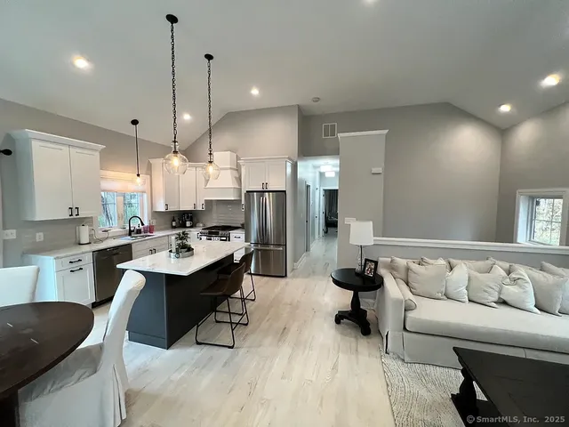 a living room with stainless steel appliances kitchen island granite countertop furniture and a view of kitchen