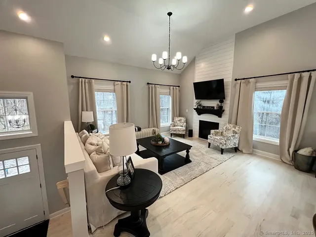 a living room with furniture a chandelier and a flat screen tv