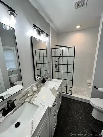 a bathroom with a sink and mirror with toilet