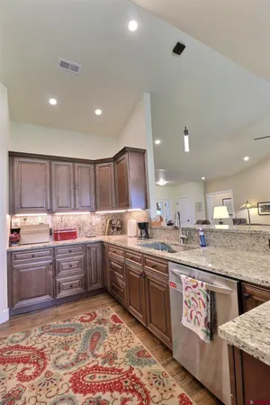 a kitchen with stainless steel appliances granite countertop a refrigerator a stove and a sink