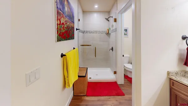 a bedroom with a bed next to a window with a chandelier