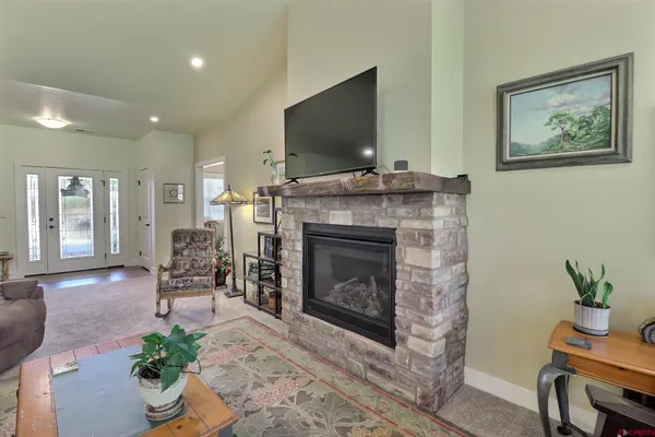 a living room with furniture a flat screen tv and a fireplace