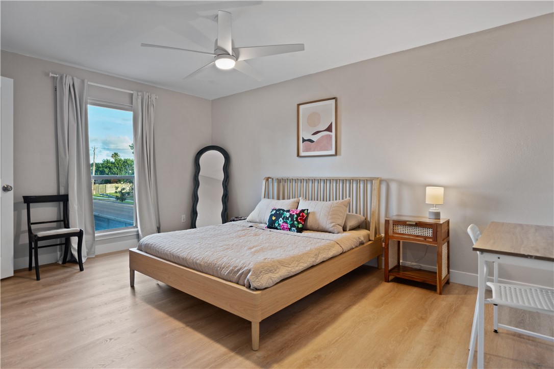 7654 Timber Crest Drive Corpus Christi, TX 78413 - Photo 16 of 35 a bedroom with a bed and a table with wooden floor