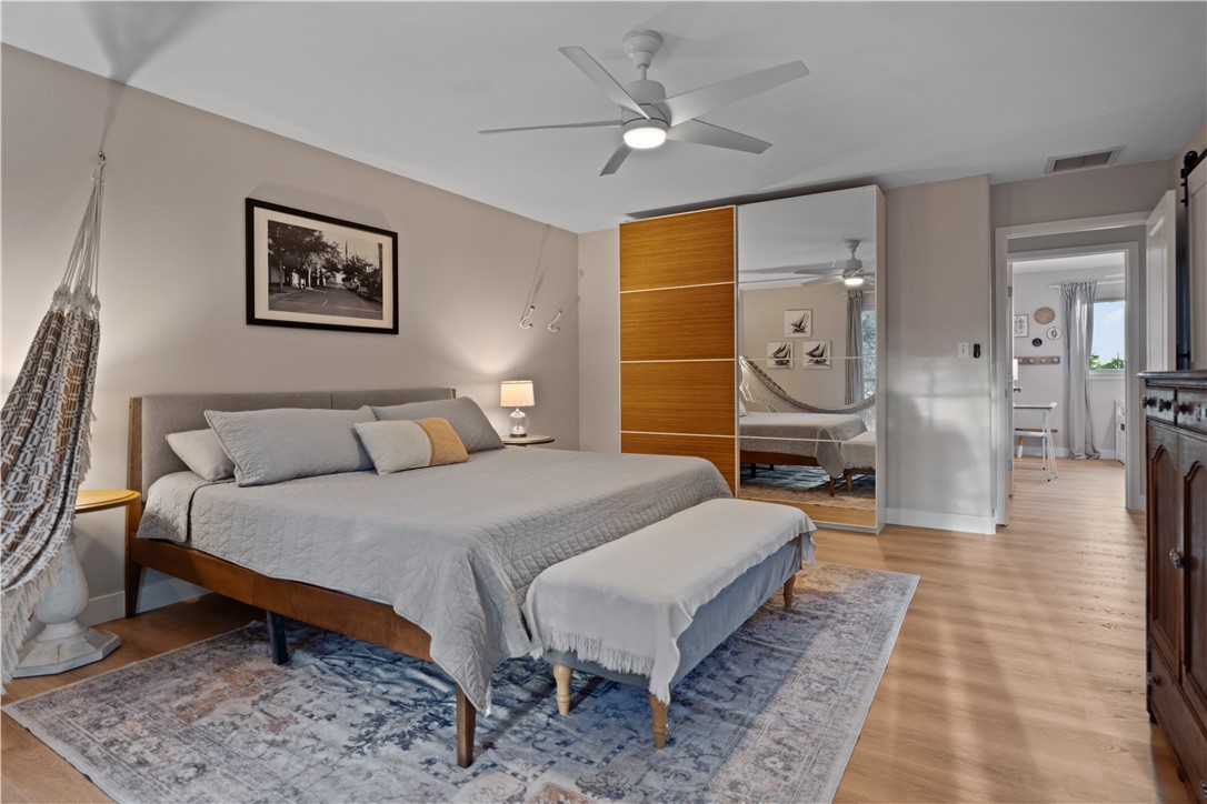 7654 Timber Crest Drive Corpus Christi, TX 78413 - Photo 21 of 35 a bedroom with a bed a mirror and a desk