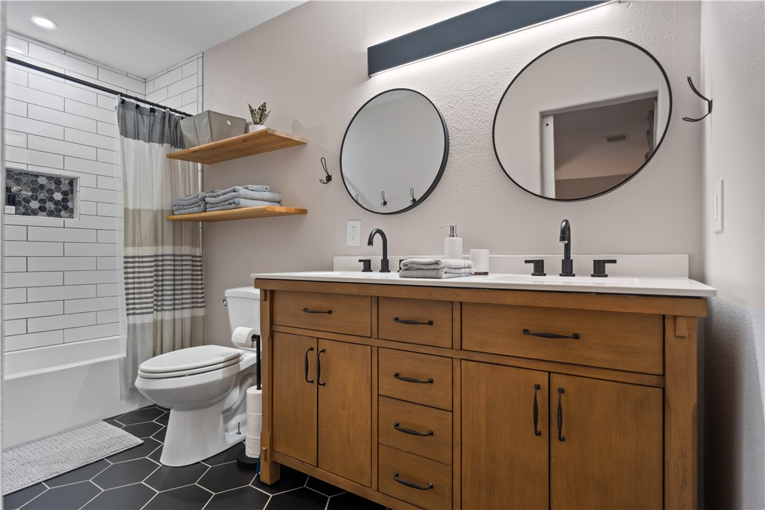 7654 Timber Crest Drive Corpus Christi, TX 78413 - Photo 23 of 35 a bathroom with a toilet a sink and mirror