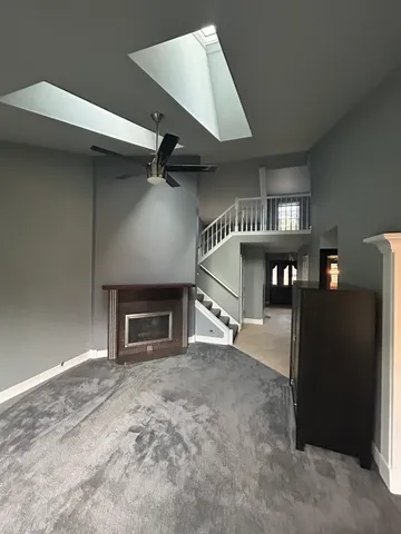 an empty room with windows and fireplace