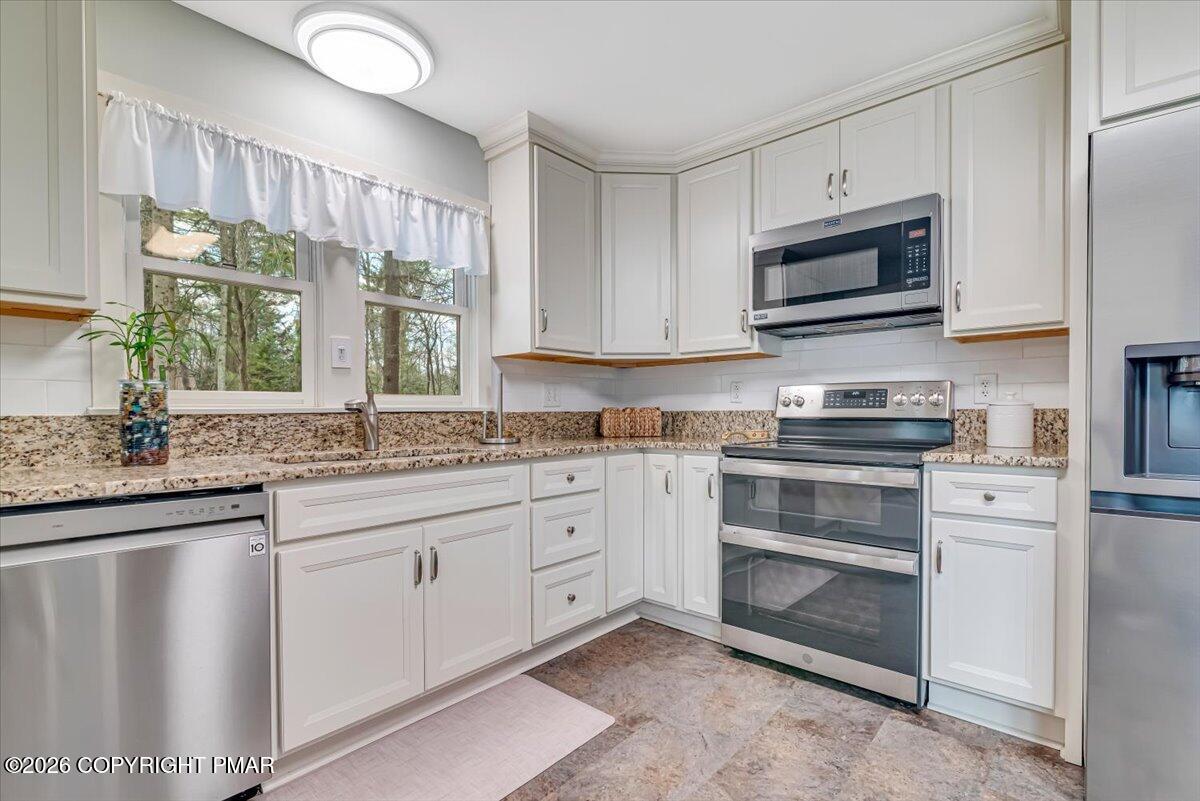 253 Thomas Road Blakeslee, PA 18610 - Photo 16 of 63 a kitchen with stainless steel appliances granite countertop white cabinets a sink and a window