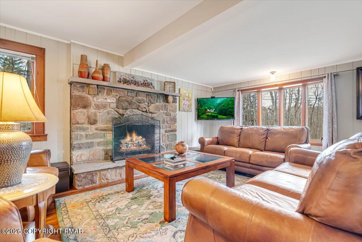 253 Thomas Road Blakeslee, PA 18610 - Photo 22 of 63 a living room with furniture a fireplace and a large window
