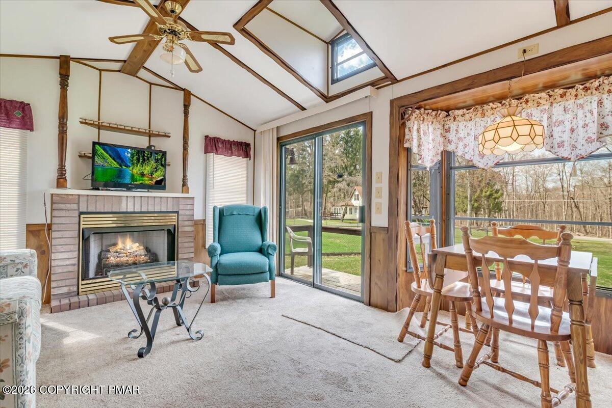253 Thomas Road Blakeslee, PA 18610 - Photo 52 of 63 a living room with furniture a fireplace and a floor to ceiling window