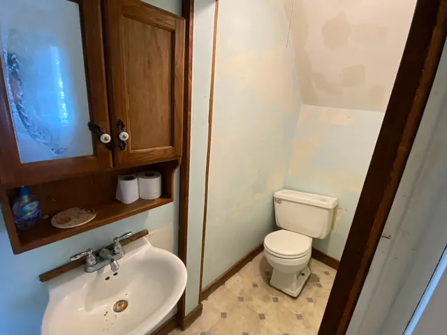a bathroom with a sink a toilet and a mirror