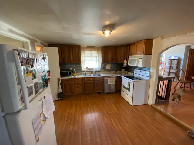 a kitchen with stainless steel appliances a sink a stove a refrigerator cabinets and a window