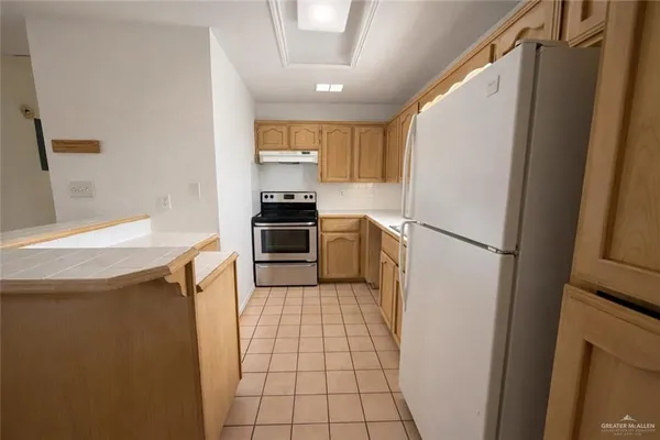 a kitchen with stainless steel appliances a refrigerator a stove a sink and a refrigerator