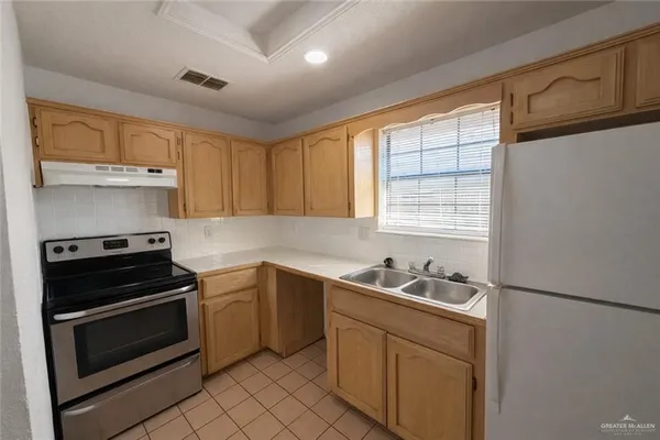 a kitchen with a sink stove top oven and cabinets