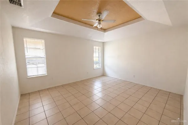 an empty room with windows and fan