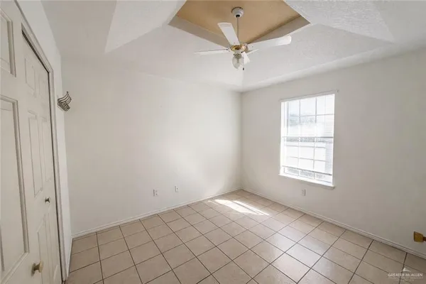 an empty room with fan and windows
