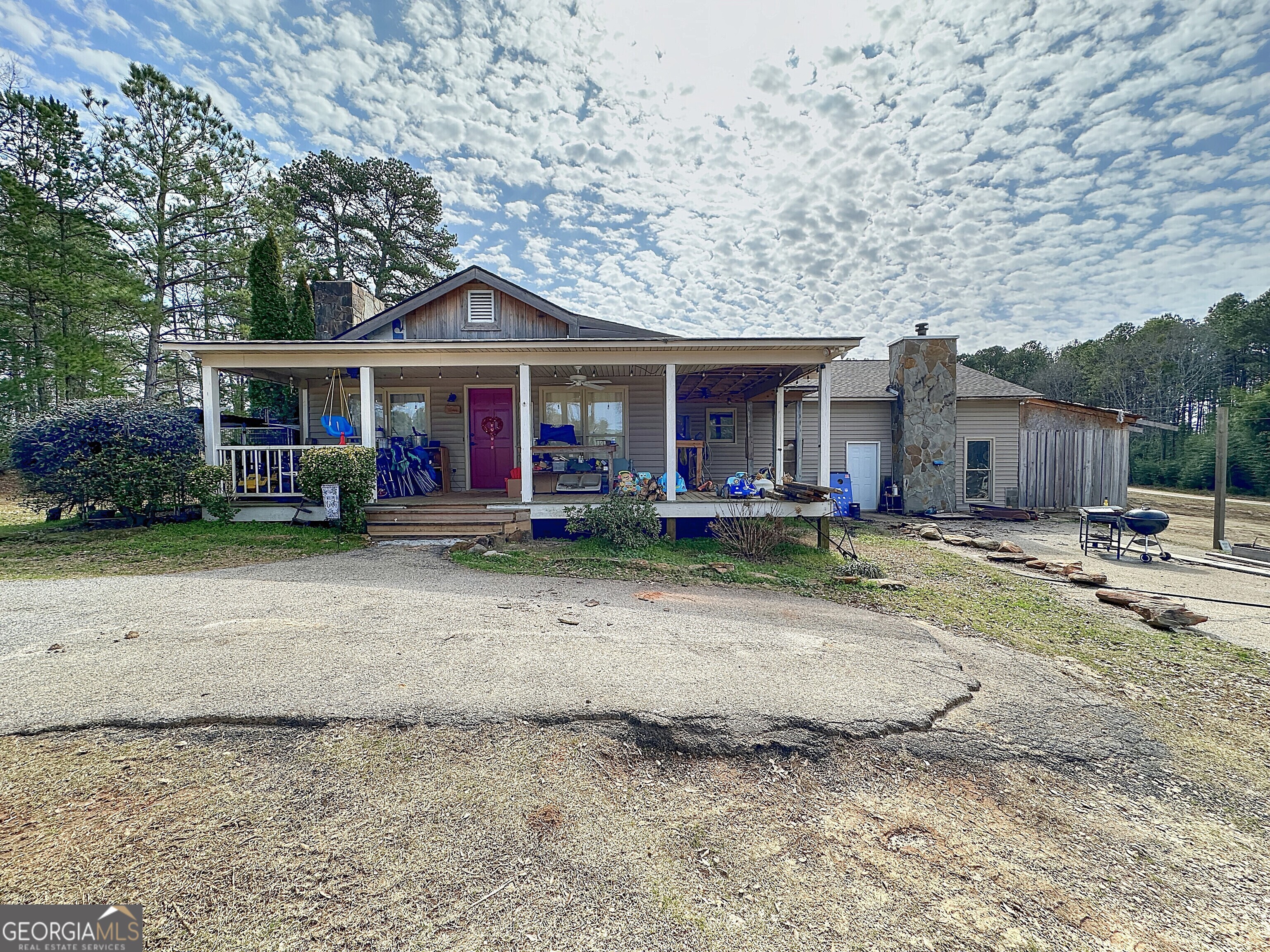 a front view of a house with a yard and trees
