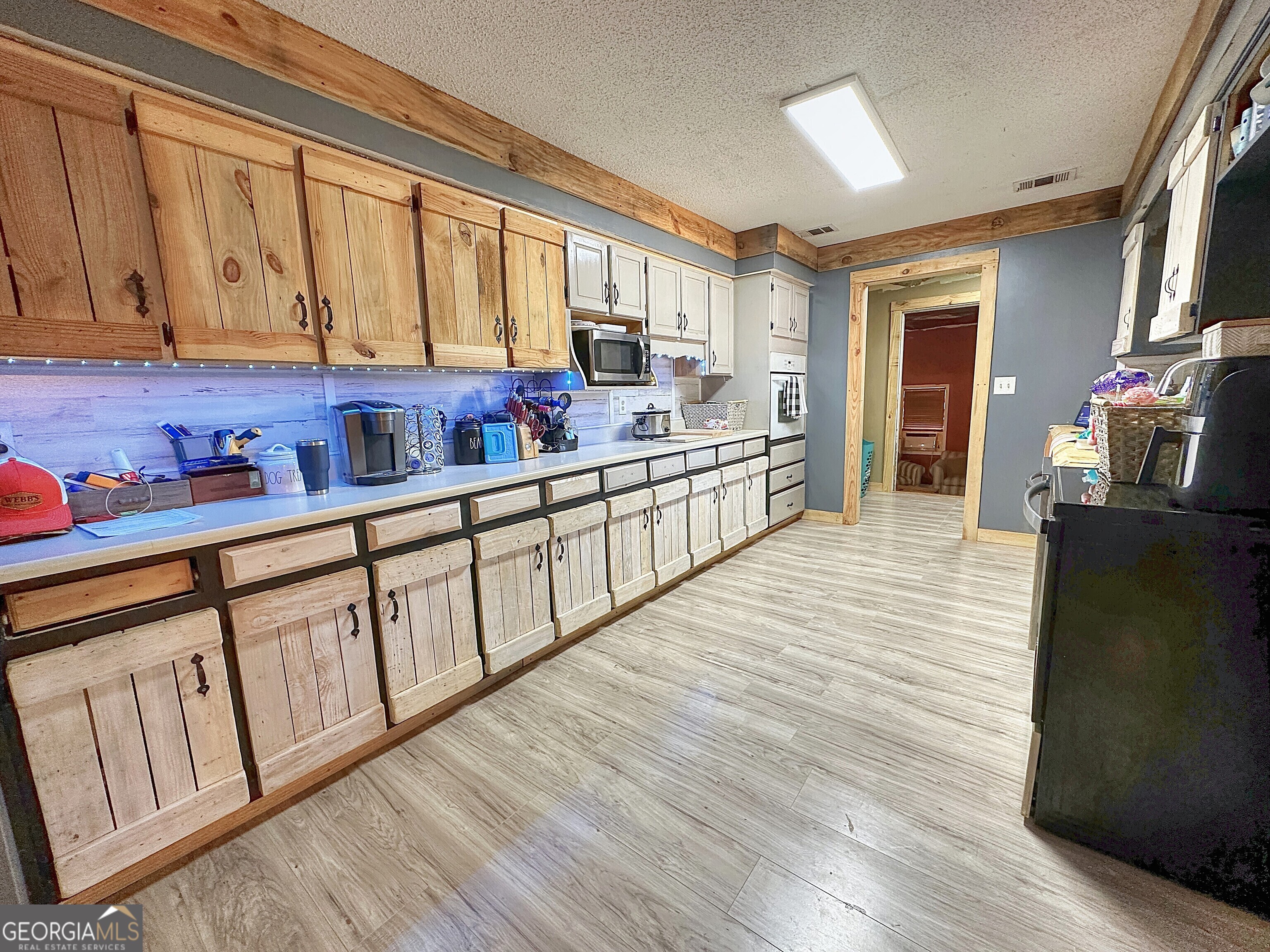 3900 Greenville Road LaGrange, GA 30241 - Photo 10 of 12 a kitchen with stainless steel appliances granite countertop a refrigerator a sink dishwasher a stove and white countertops with wooden floor