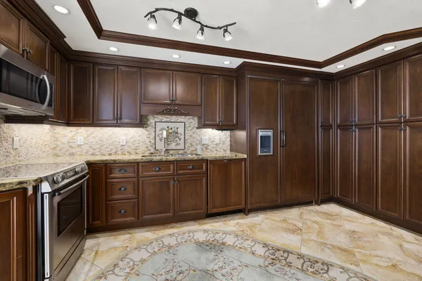 a kitchen with kitchen island granite countertop a sink cabinets and stainless steel appliances