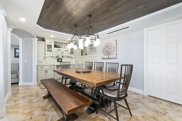 a dining room with wooden floor and chandelier