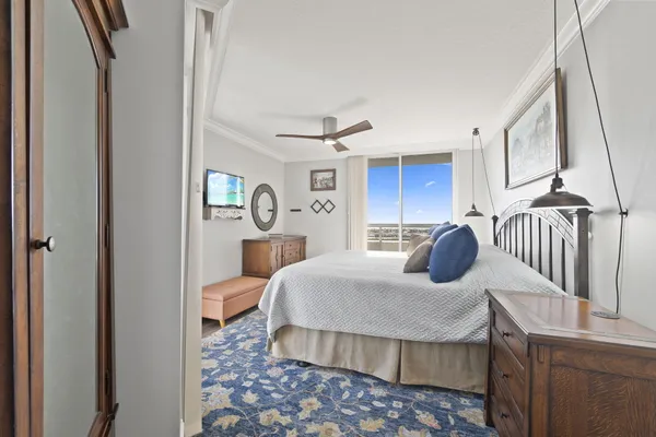a bedroom with a large bed and a chandelier