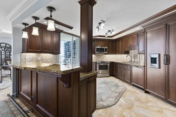 a kitchen with stainless steel appliances granite countertop a stove top oven a sink and dishwasher