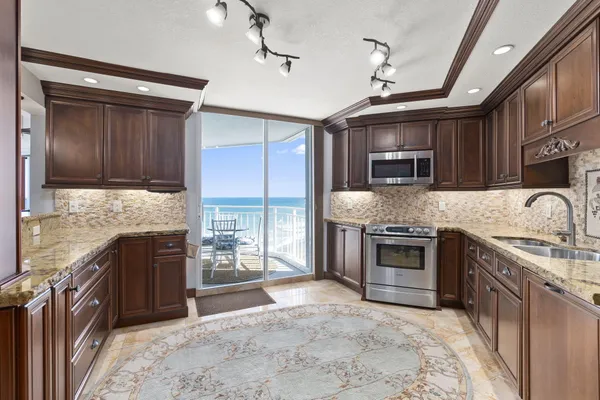 a kitchen with stainless steel appliances granite countertop a sink and a stove