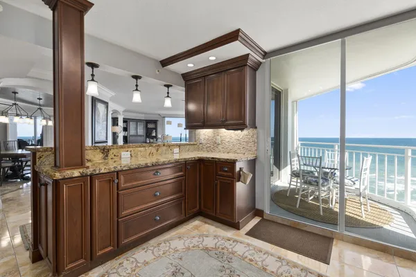 a kitchen with stainless steel appliances granite countertop wooden cabinets a refrigerator and a sink
