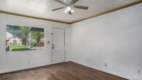 an empty room with windows and ceiling fan