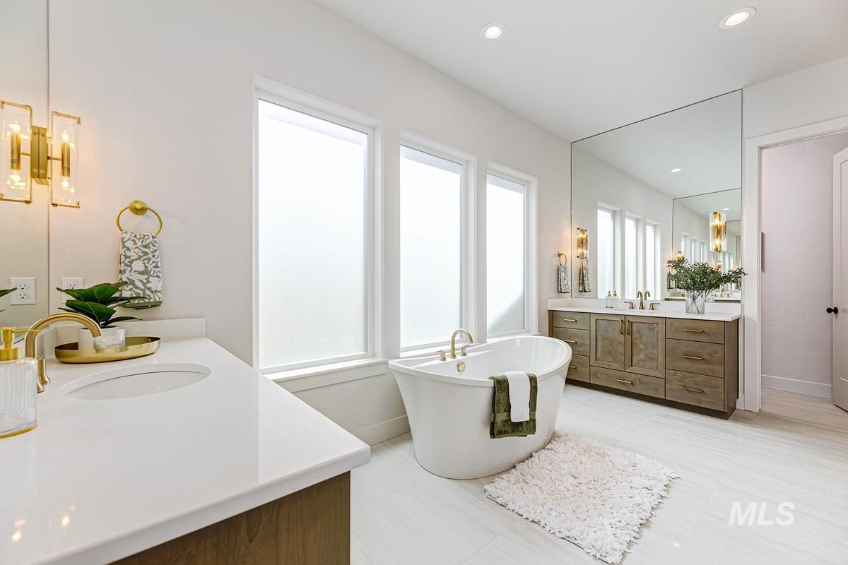 7026 Saddle Bred Way Star, ID 83669 - Photo 19 of 49 Full bathroom featuring two vanities, a freestanding tub, and recessed lighting