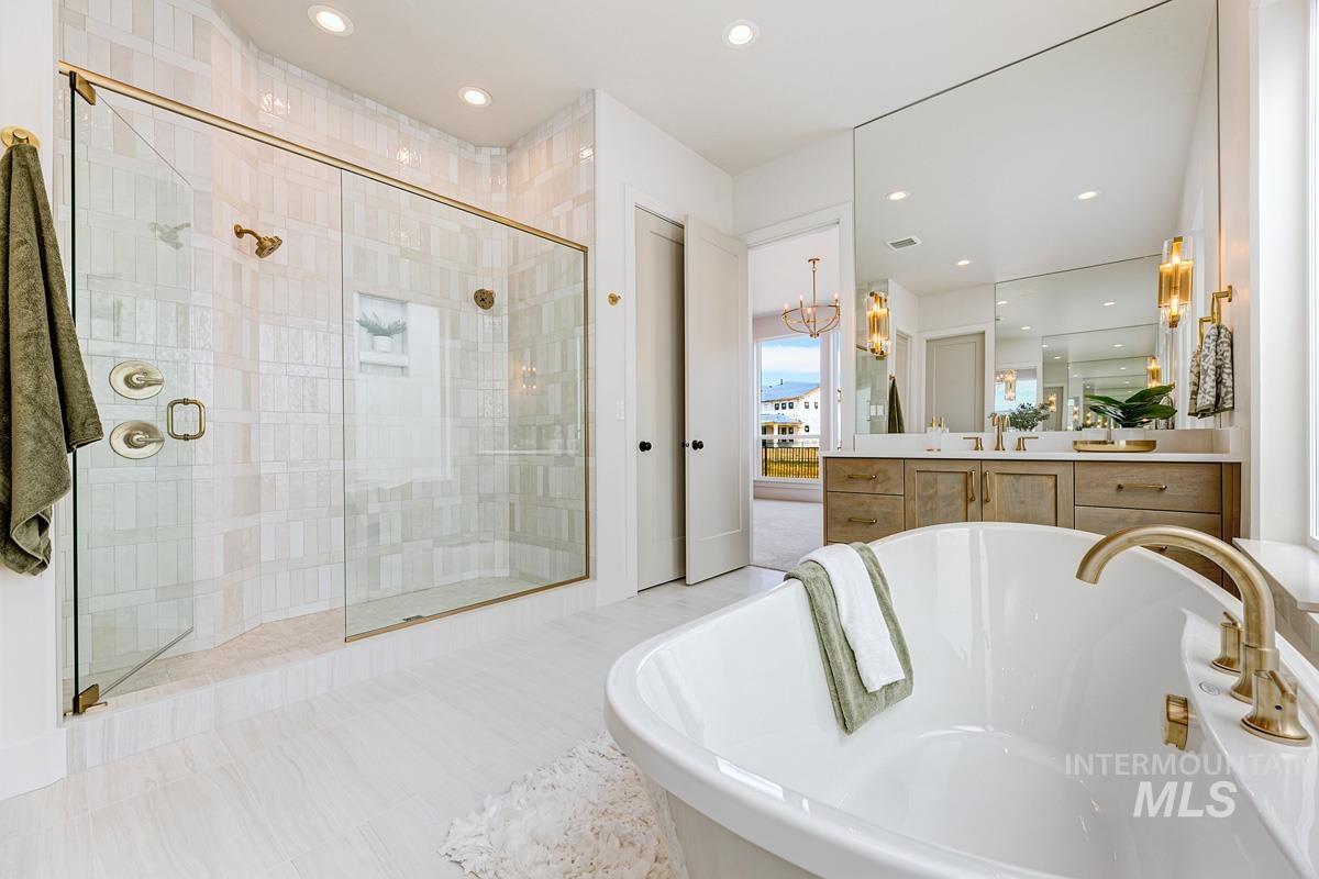 7026 Saddle Bred Way Star, ID 83669 - Photo 20 of 49 Full bath with vanity, a shower stall, a freestanding bath, and a chandelier