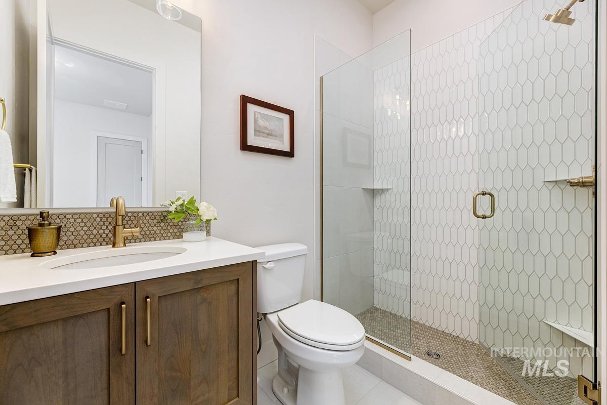 7026 Saddle Bred Way Star, ID 83669 - Photo 30 of 49 Bathroom featuring vanity, a shower stall, and decorative backsplash