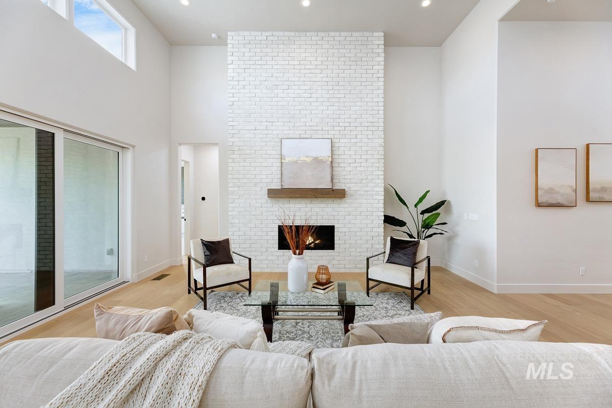 7026 Saddle Bred Way Star, ID 83669 - Photo 3 of 49 Living room with a brick fireplace, a high ceiling, light wood finished floors, and recessed lighting