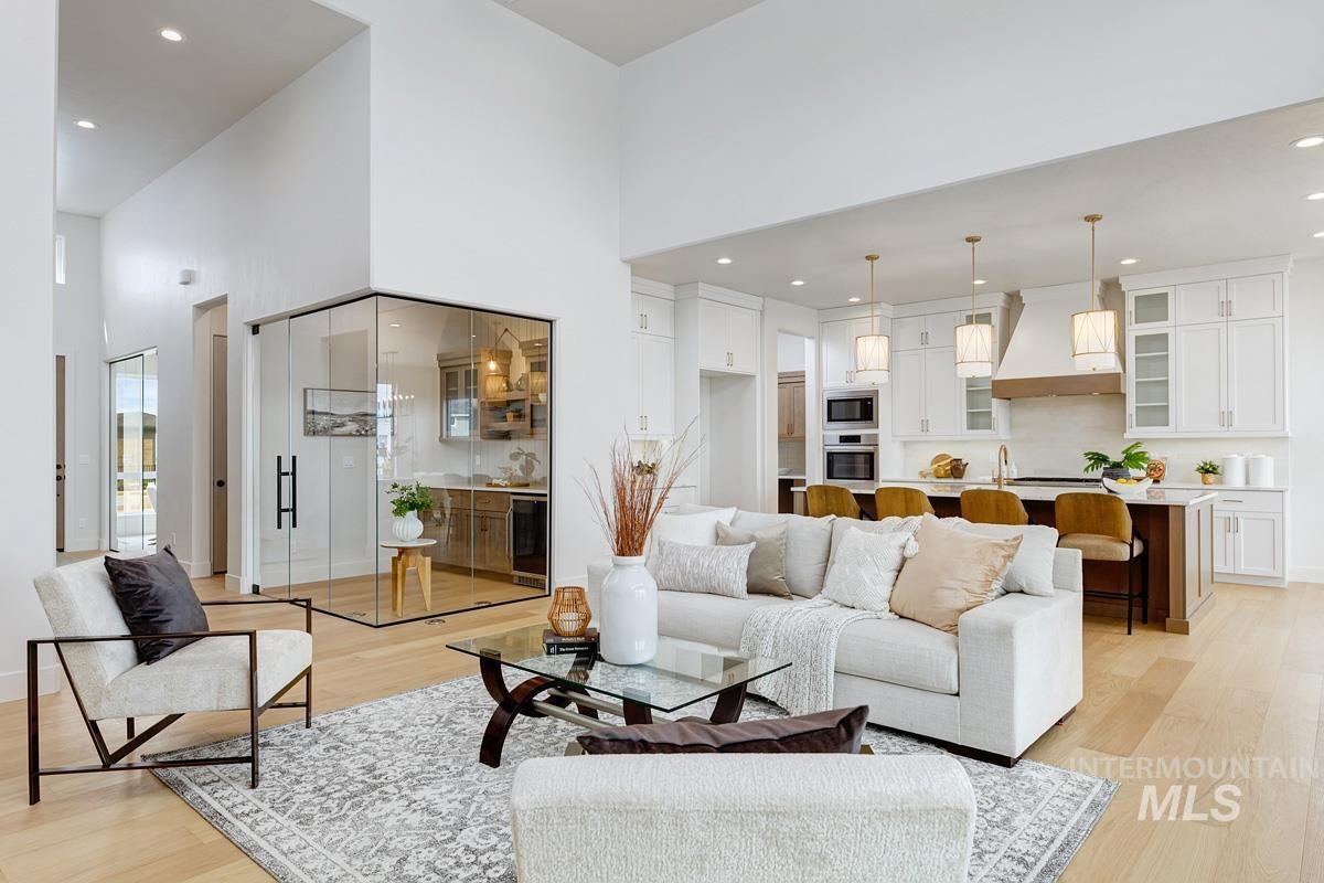 7026 Saddle Bred Way Star, ID 83669 - Photo 6 of 49 Living room featuring light wood-type flooring, recessed lighting, a high ceiling, and wine cooler