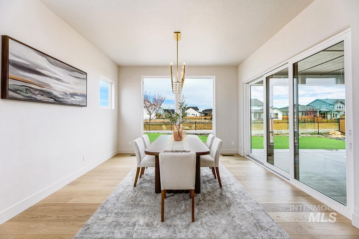 7026 Saddle Bred Way Star, ID 83669 - Photo 10 of 49 Dining room with a residential view, light wood-type flooring, and hanging lights