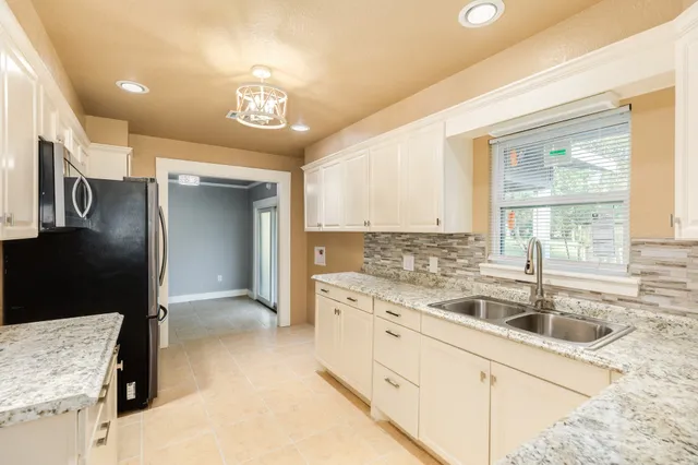 a kitchen with granite countertop a sink stainless steel appliances and cabinets