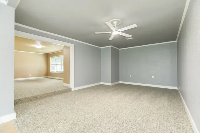a view of an empty room with a ceiling fan