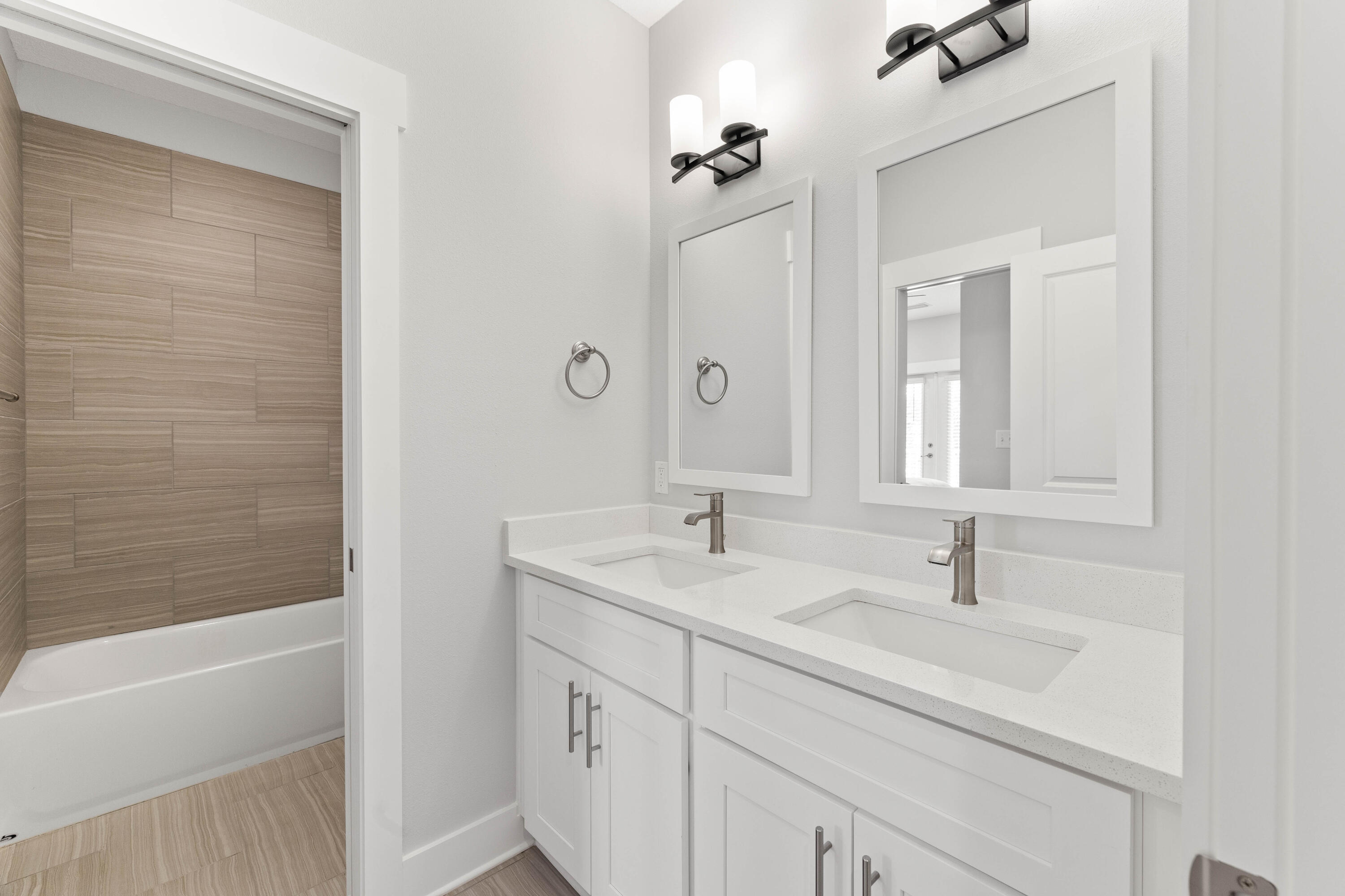 100 Beach Drive, Unit 9 Destin, FL 32541 - Photo 25 of 33 a bathroom with a sink double vanity granite tub shower and a mirror