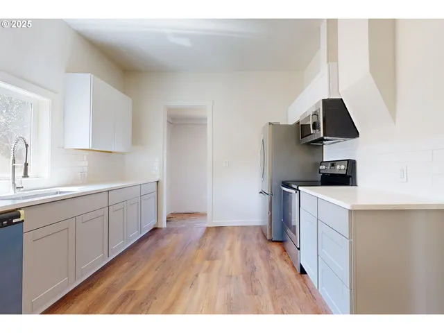 a kitchen with a sink and a stove top oven